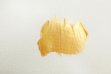 Photo of Golden paint brush strokes on white background