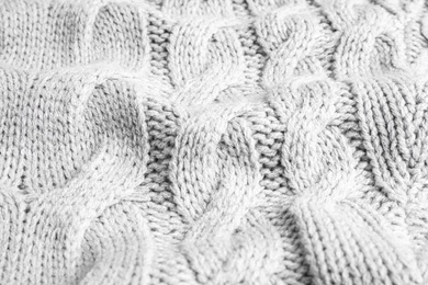 Grey knitted sweater as background, closeup view