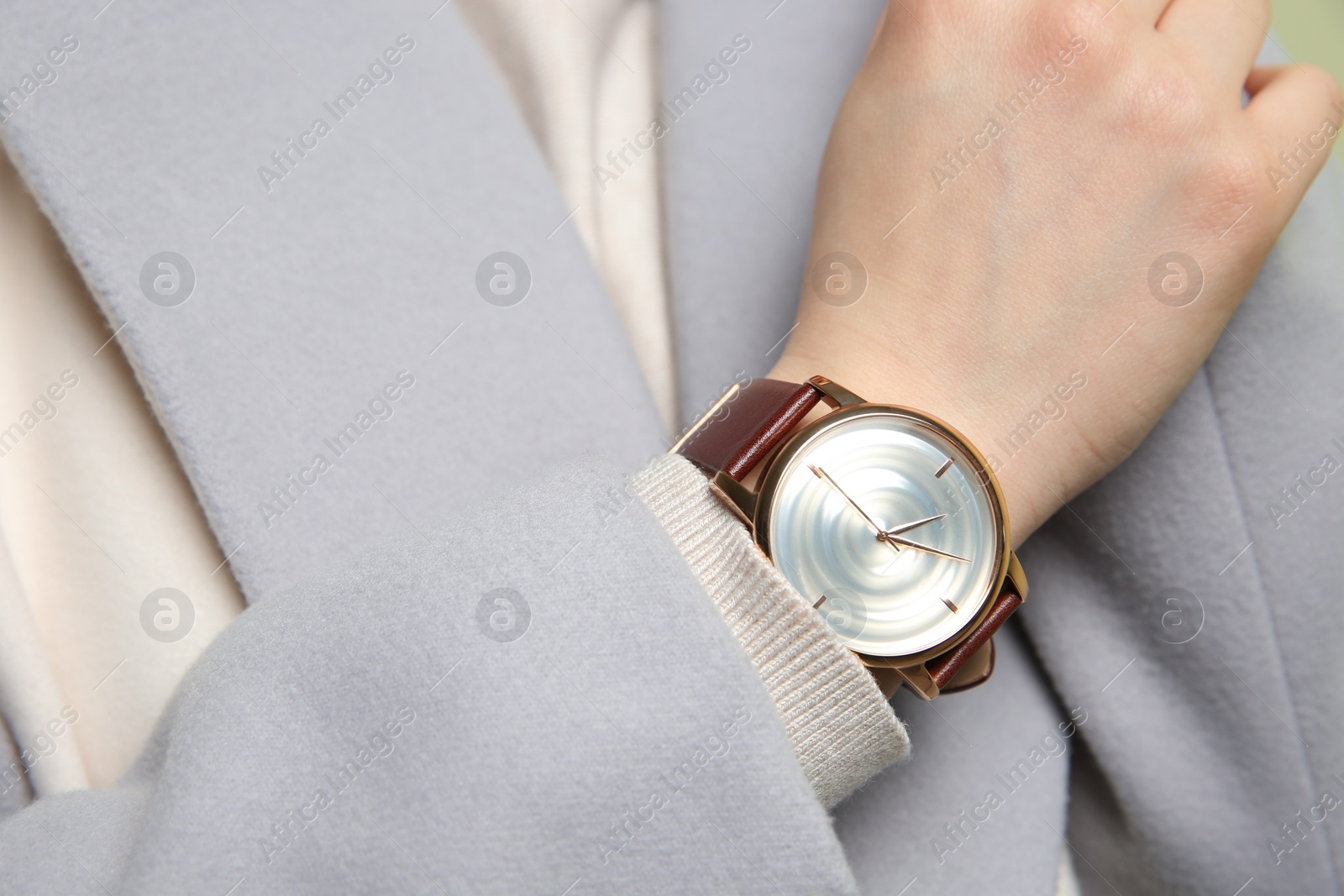 Photo of Woman in grey jacket with luxury wristwatch, closeup