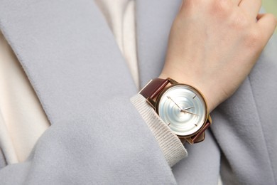 Photo of Woman in grey jacket with luxury wristwatch, closeup