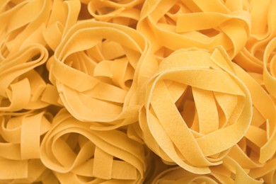 Photo of Raw tagliatelle pasta as background, top view