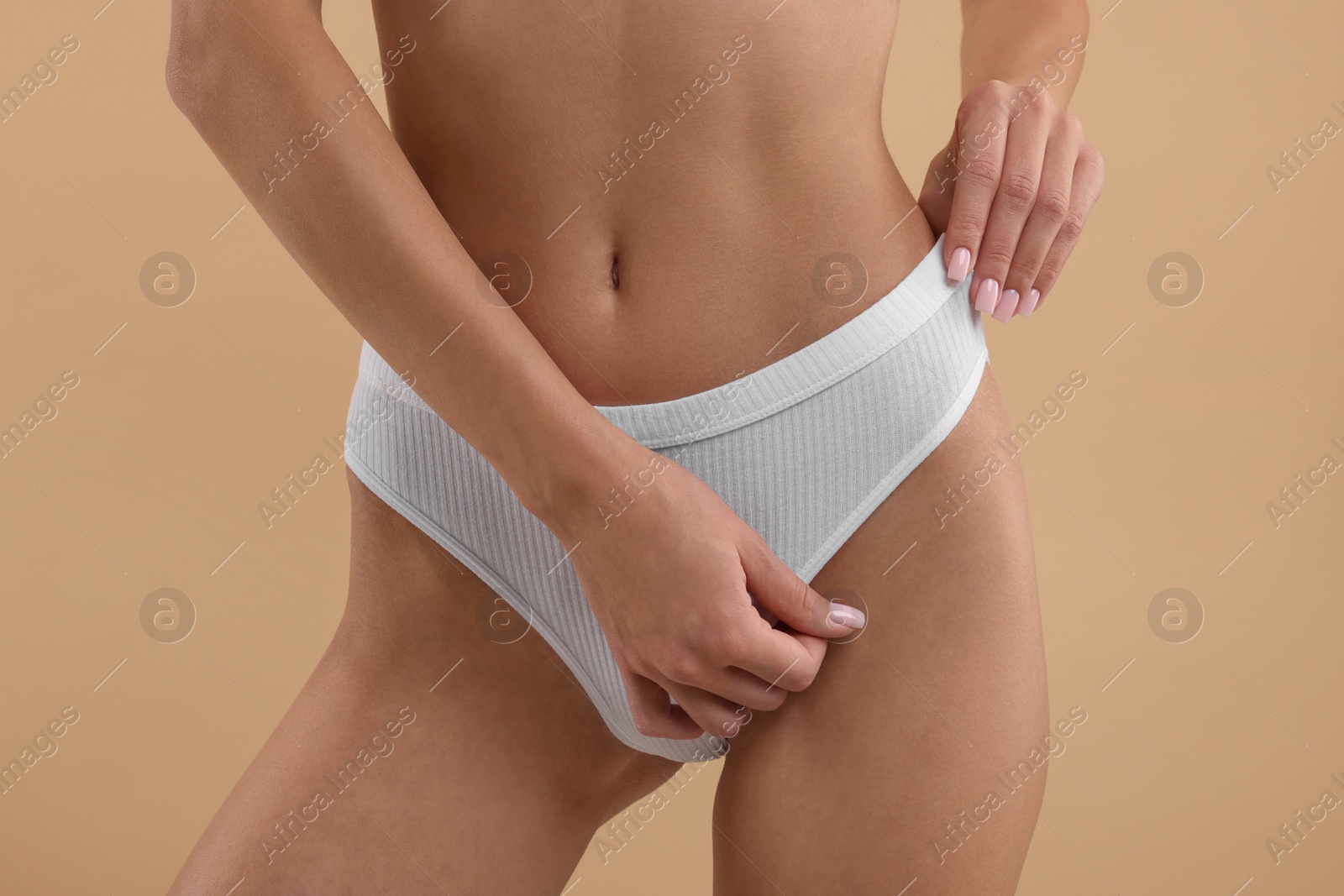 Photo of Young woman in stylish white bikini on beige background, closeup