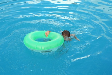 Little child with inflatable ring in outdoor swimming pool. Dangerous situation