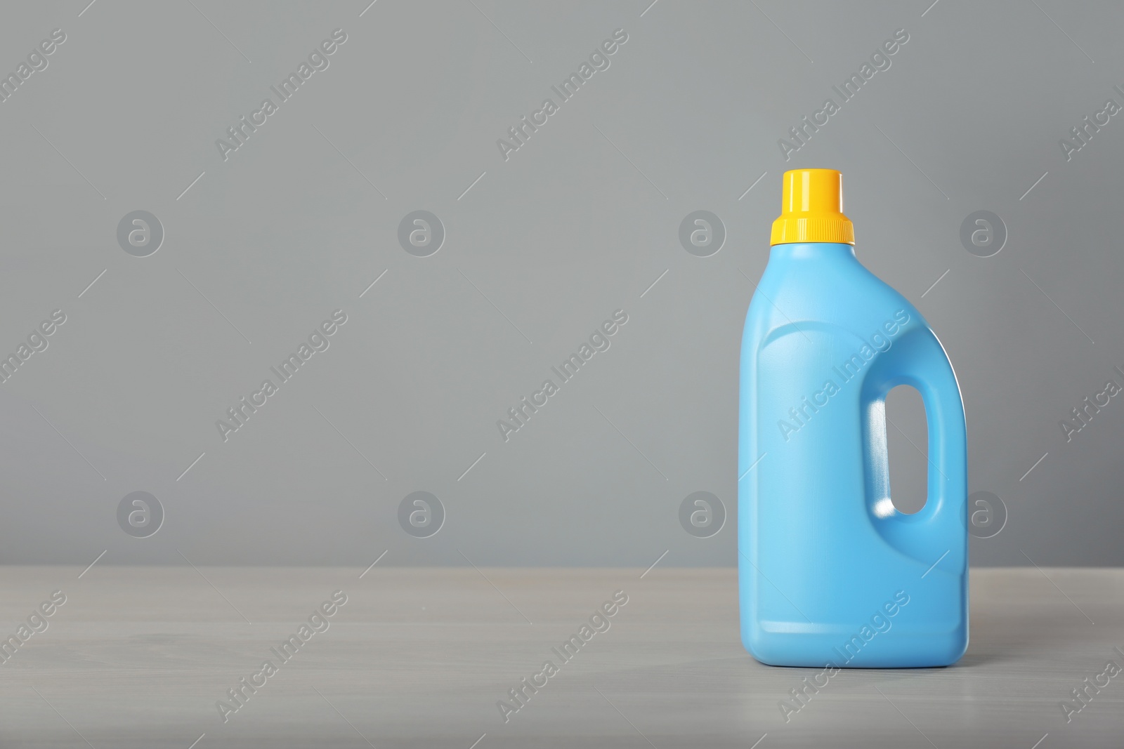 Photo of Bottle of cleaning product on light table. Space for text