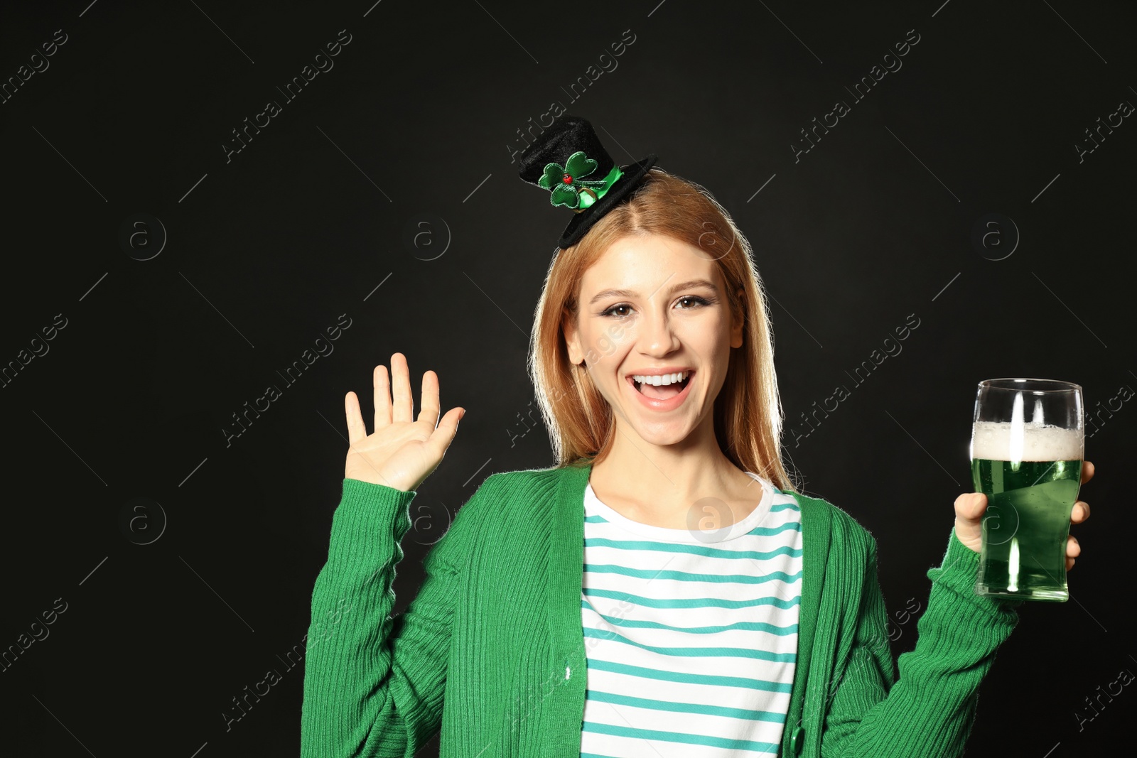 Photo of Young woman with green beer on black background. St. Patrick's Day celebration