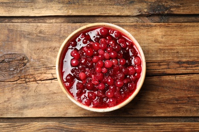 Photo of Fresh cranberry sauce on wooden table, top view