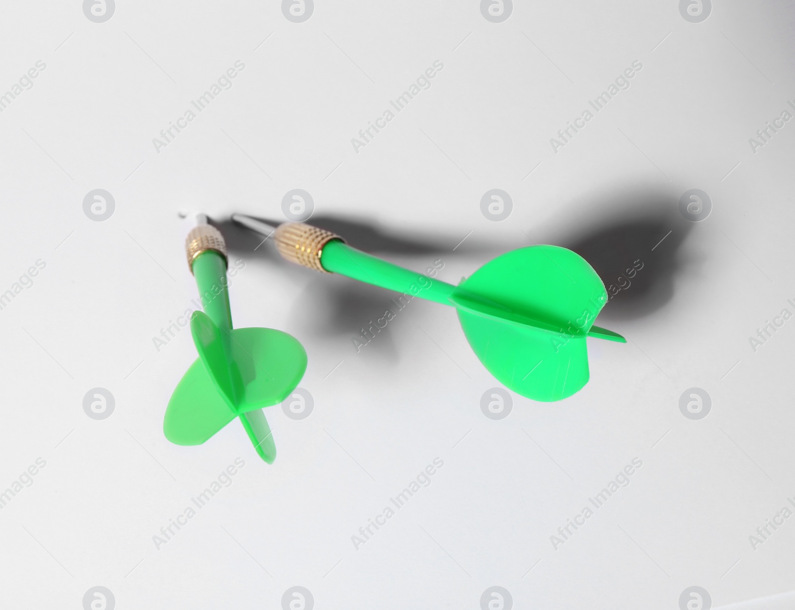 Photo of Green dart arrows for game on white background, above view