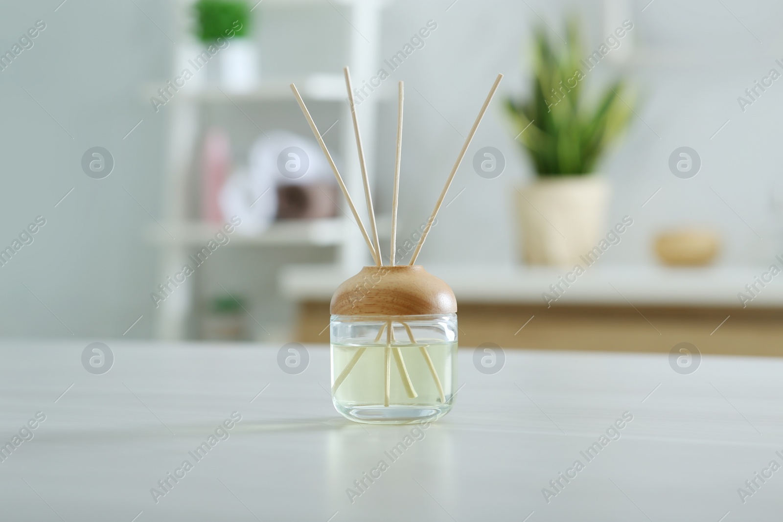 Photo of Aromatic reed air freshener on table indoors