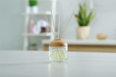 Photo of Aromatic reed air freshener on table indoors