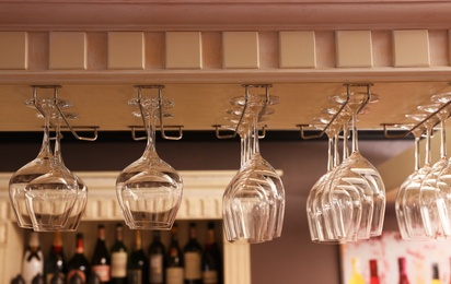 Set of empty clean glasses on bar racks