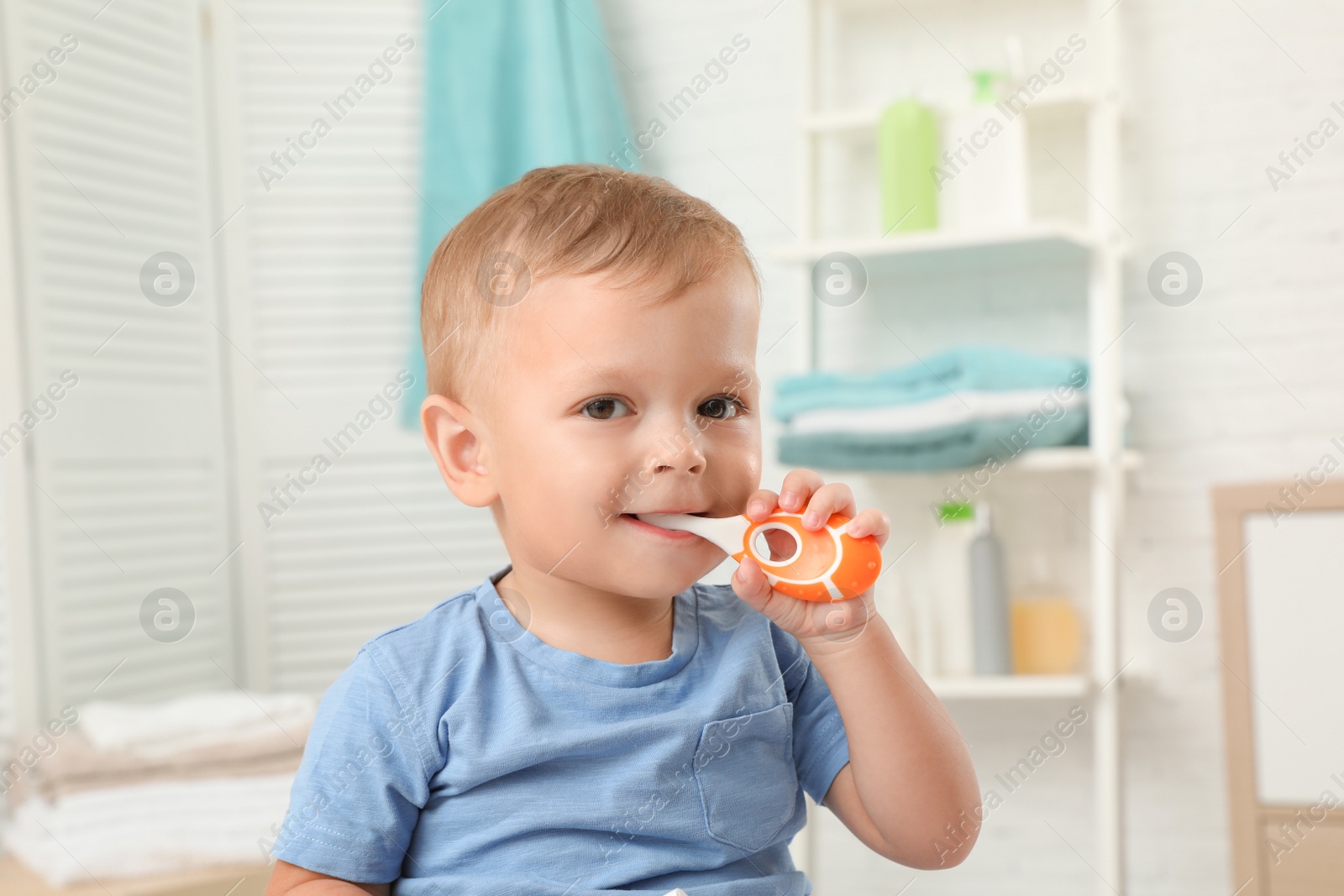 Photo of Cute little boy with toothbrush on blurred background