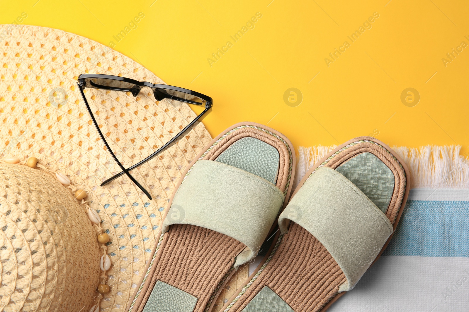 Photo of Flat lay composition with beach accessories on yellow background, space for text