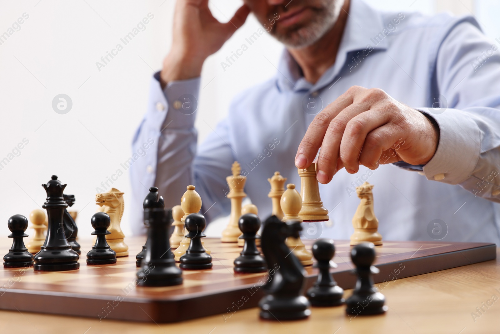 Photo of Man playing chess during tournament at table, closeup