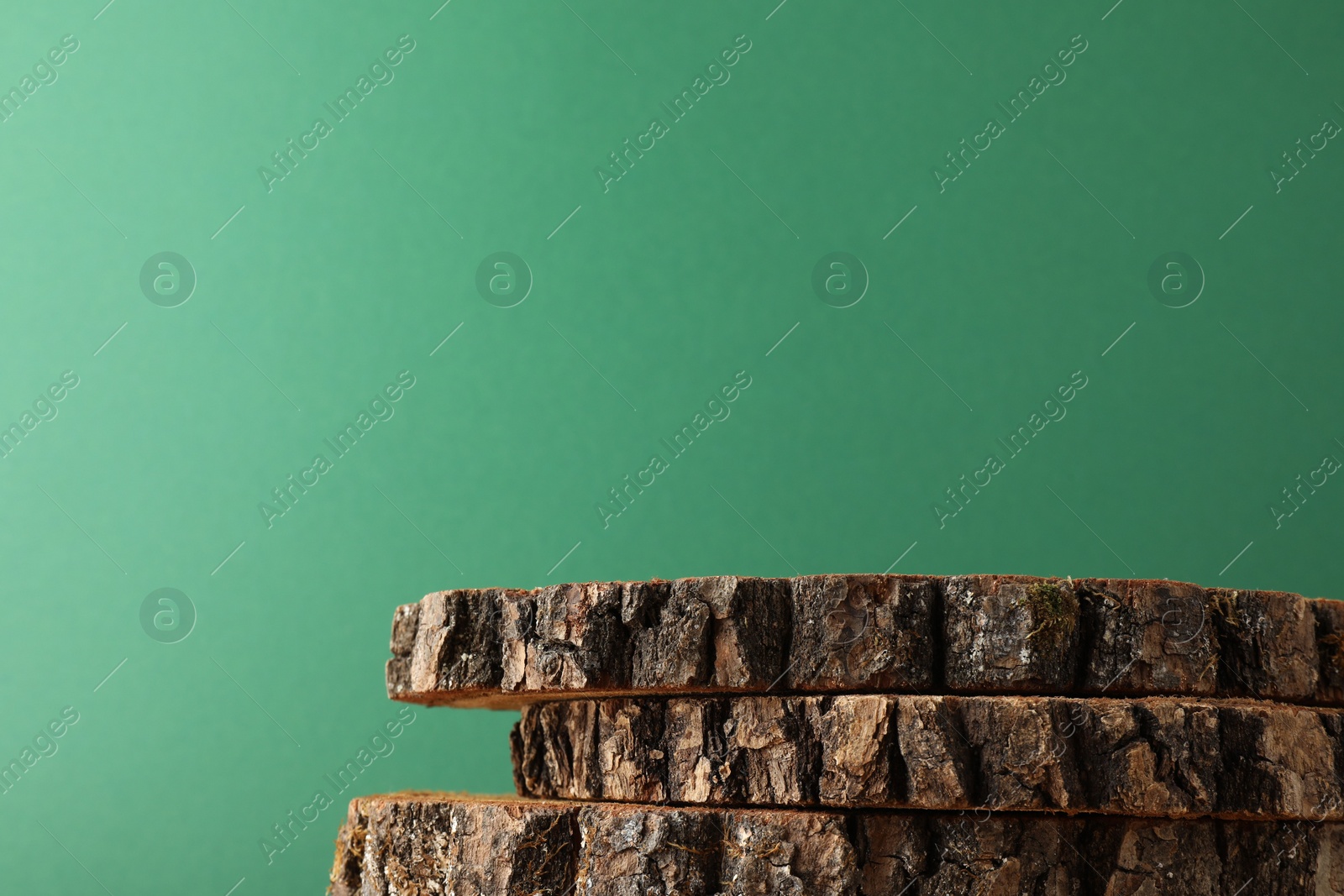 Photo of Presentation for product. Wooden stumps on green background. Space for text