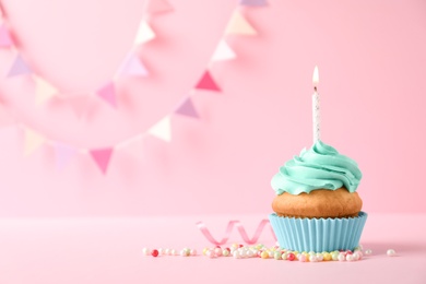Photo of Delicious birthday cupcake with candle and space for text on color background