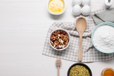 Different ingredients for making delicious baklava on white wooden table, flat lay. Space for text