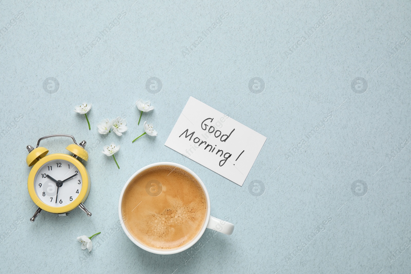 Photo of Flat lay composition with message GOOD MORNING and coffee on light blue background. Space for text