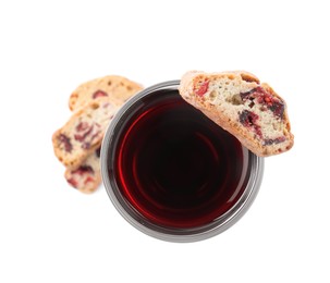 Photo of Tasty cantucci with berries and glass of liqueur on white background, top view. Traditional Italian almond biscuits