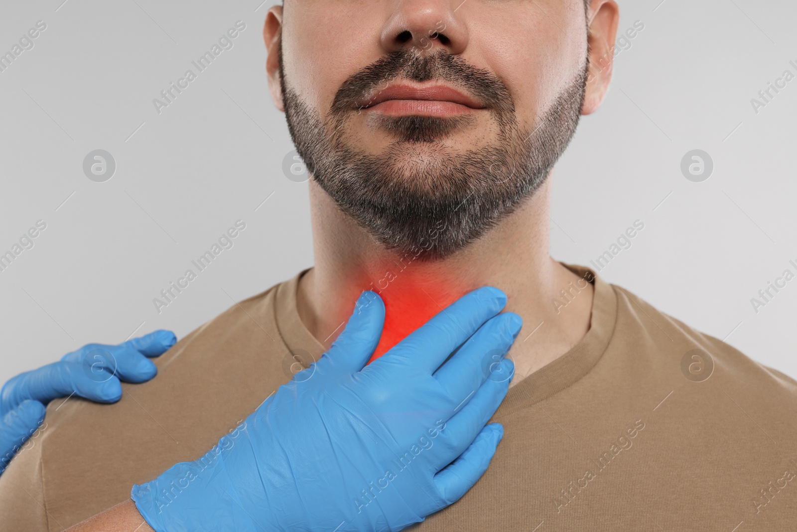 Image of Endocrinologist examining thyroid gland of patient on light grey background, closeup