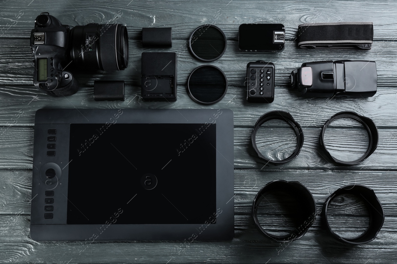 Photo of Flat lay composition with equipment for professional photographer on grey wooden table