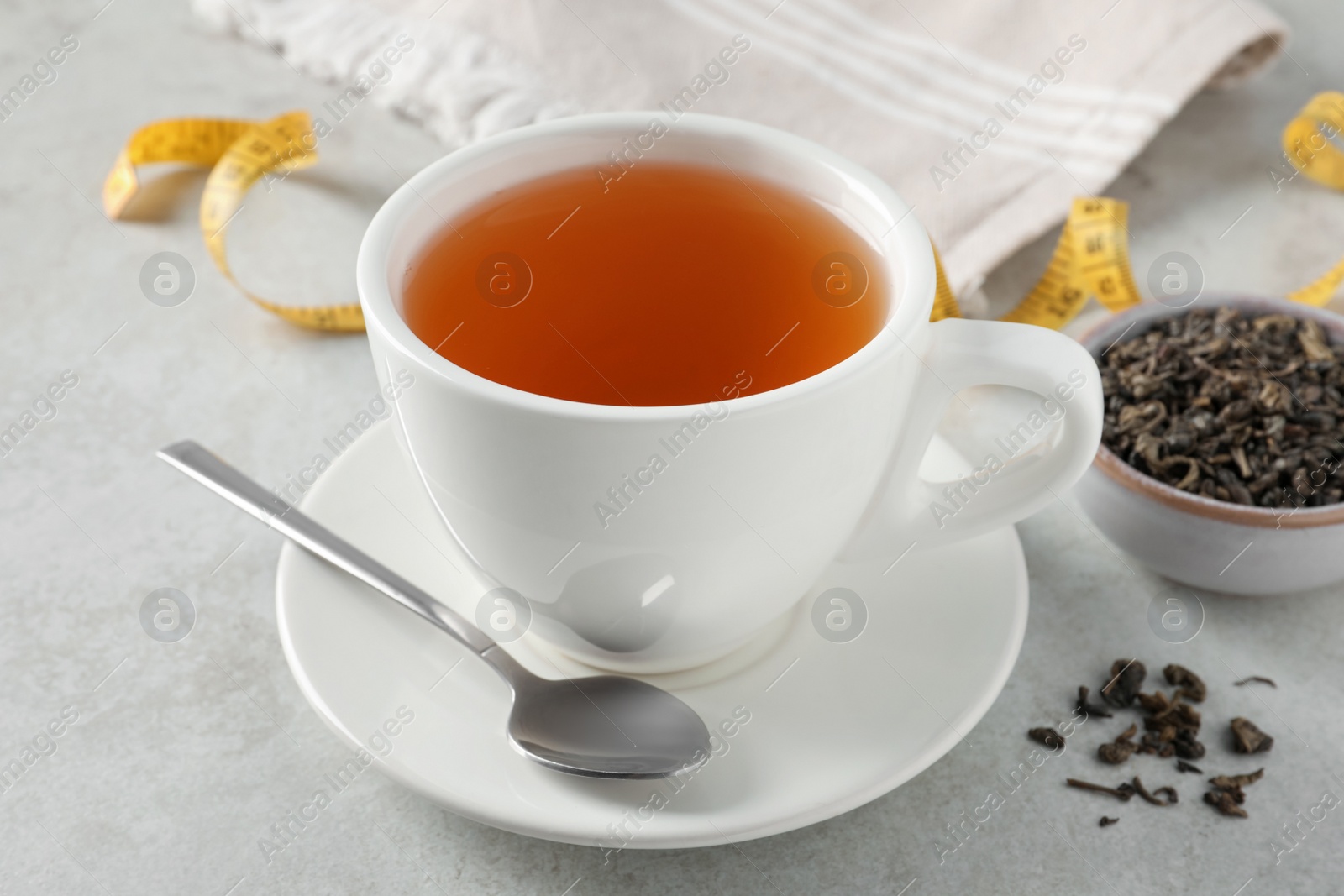 Photo of Cup of herbal diet tea on white table, closeup. Weight loss concept