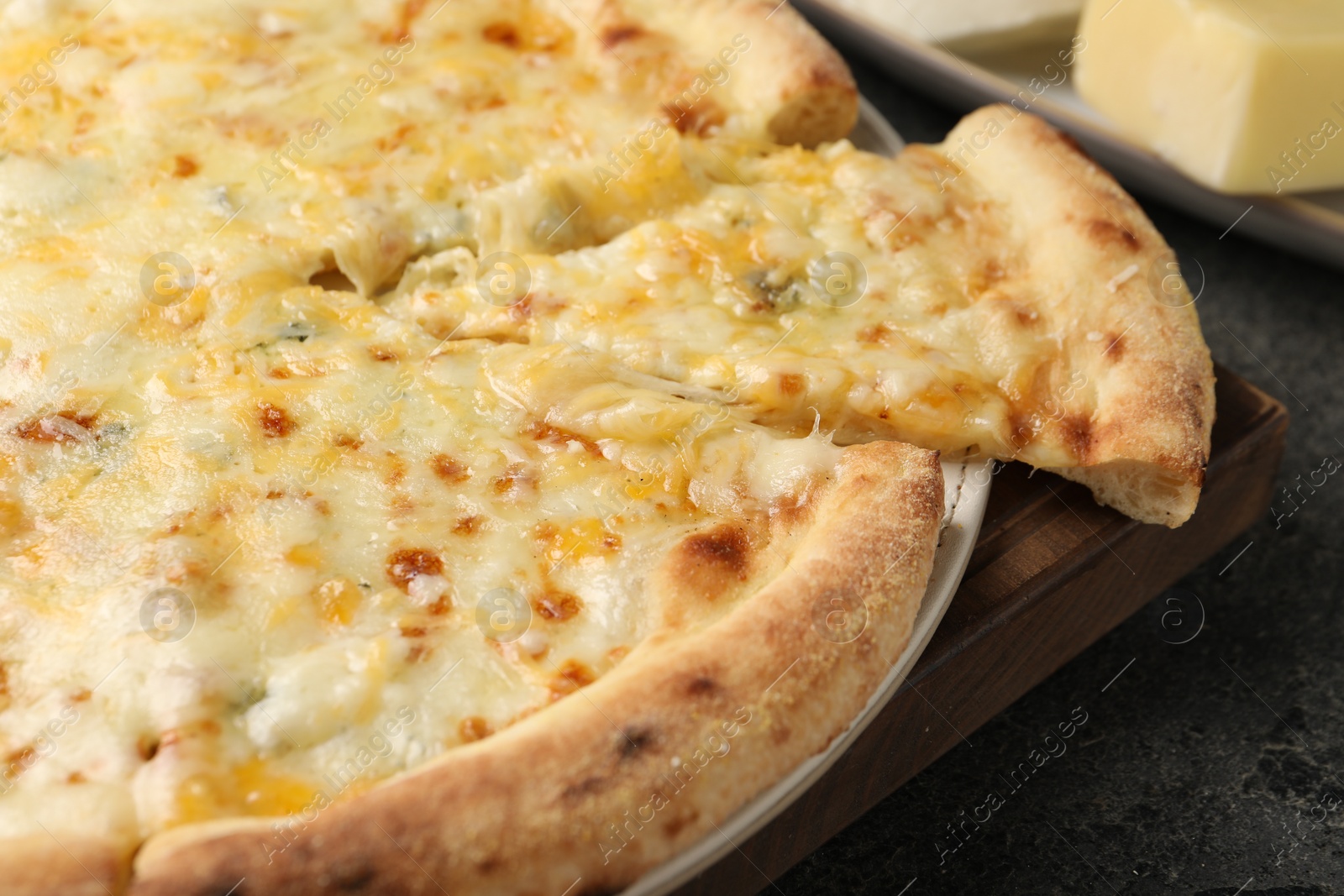 Photo of Delicious cheese pizza on dark grey table, closeup