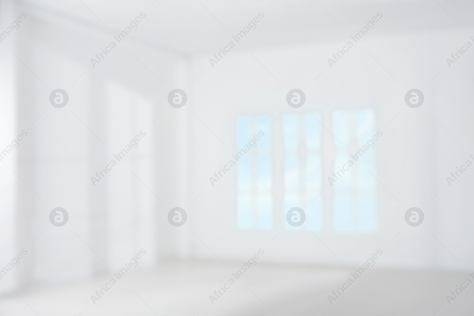 Photo of Empty room with white walls and large window, blurred view