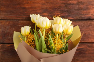 Photo of Bouquet with beautiful tulips and mimosa flowers on wooden table, top view