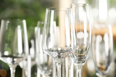 Photo of Clean empty glasses on blurred background, closeup