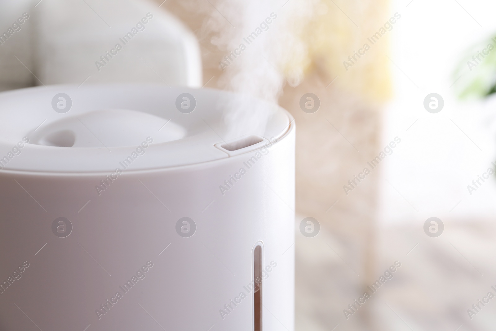 Photo of Modern air humidifier at home, closeup view. Space for text