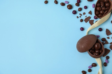 Photo of Flat lay composition with delicious chocolate Easter eggs on light blue background. Space for text