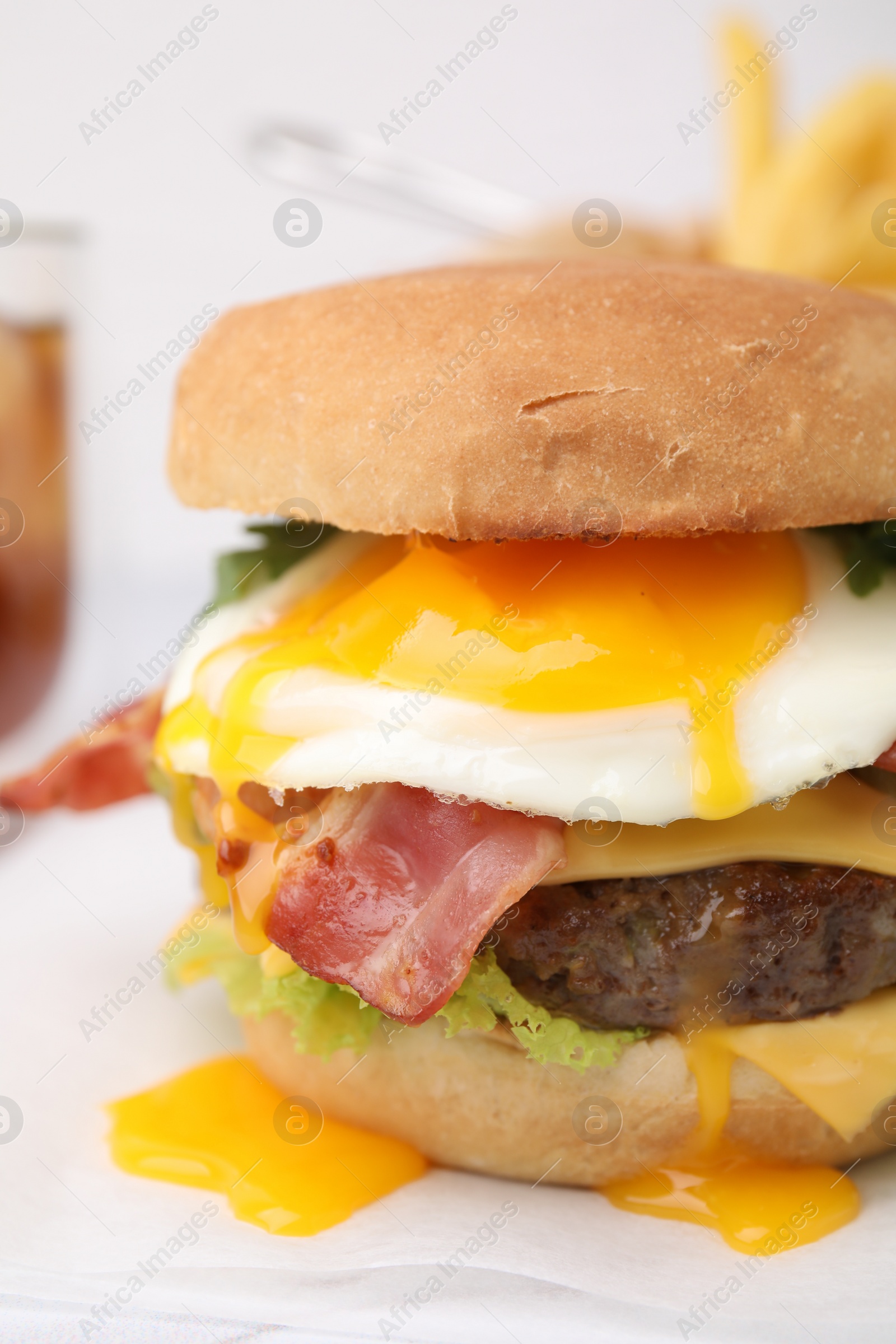 Photo of Delicious burger with fried egg on white table, closeup