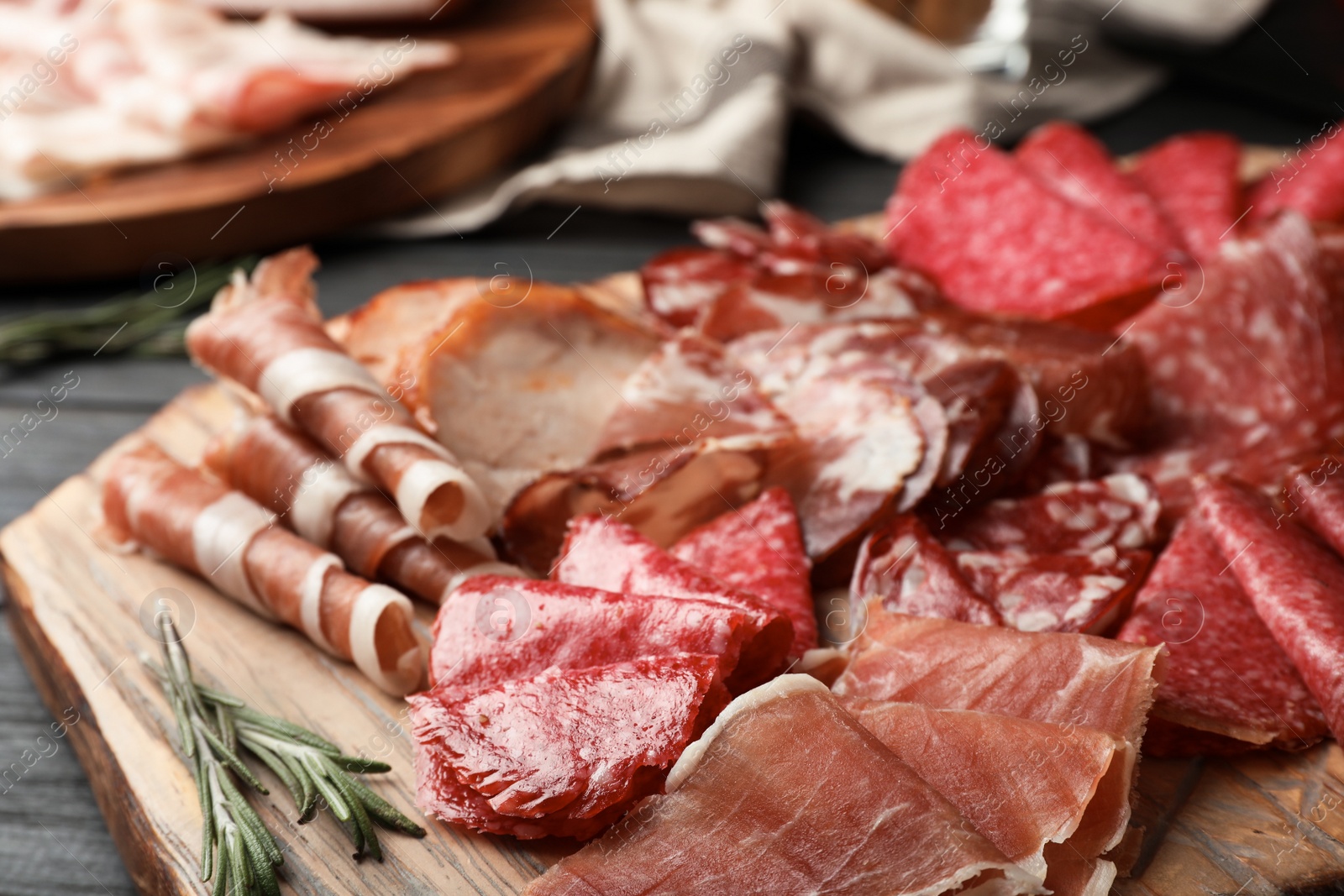 Photo of Cutting board with different sliced meat products served on table