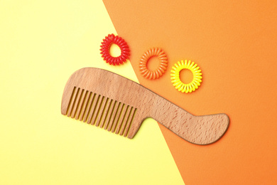 Photo of Flat lay composition with wooden hair comb on color background