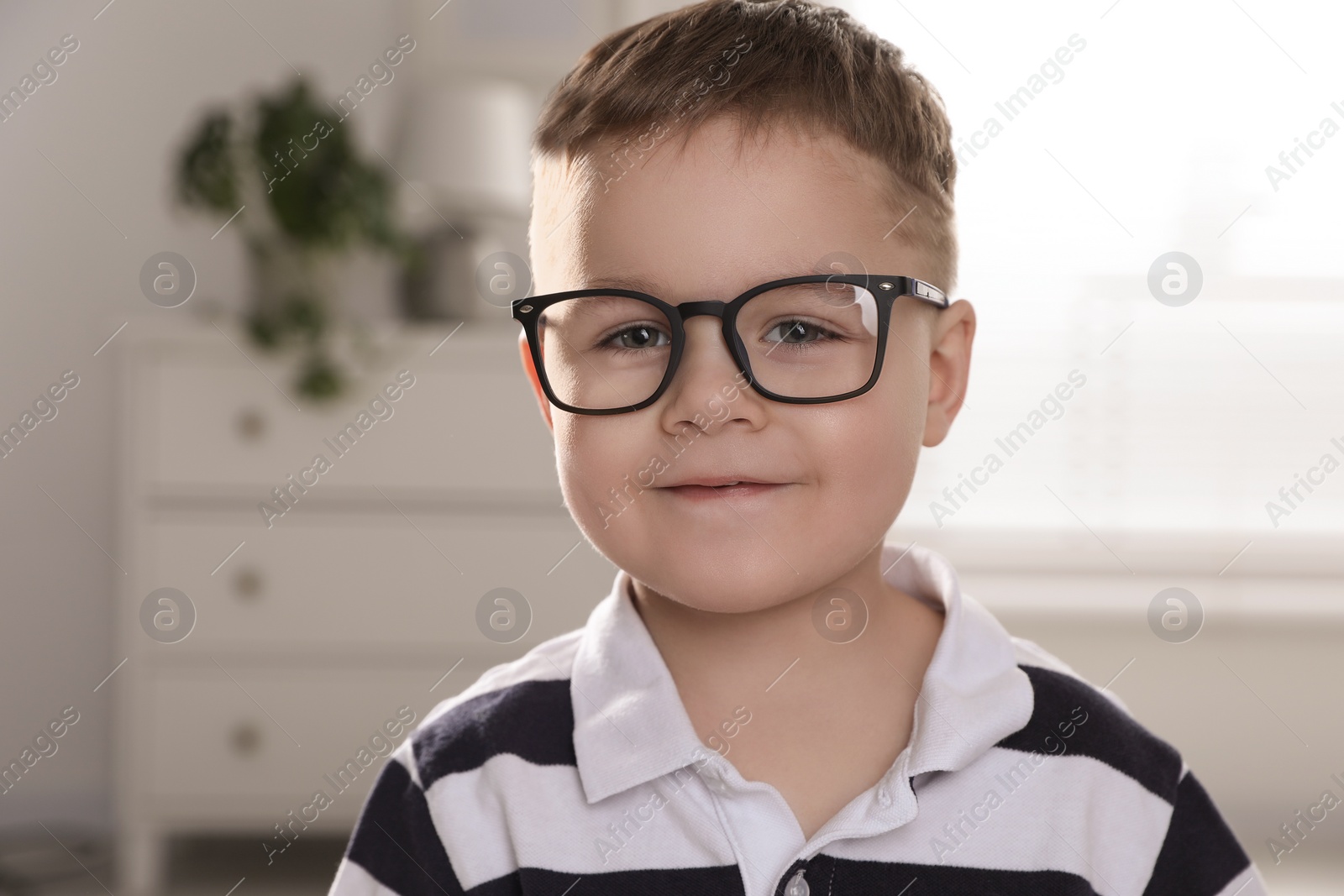 Photo of Cute little boy in glasses at home