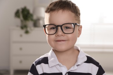 Photo of Cute little boy in glasses at home