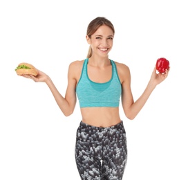 Photo of Young woman holding burger and bell pepper on white background. Choice between diet and unhealthy food