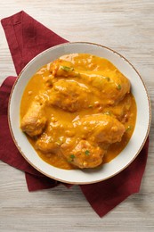 Tasty chicken curry on wooden table, top view