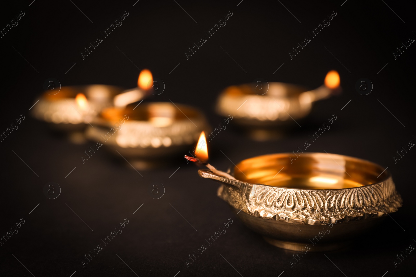 Photo of Diwali diyas or clay lamps on dark background