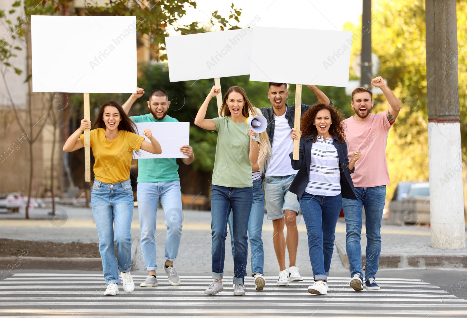 Photo of Emotional young woman with megaphone leading demonstration outdoors