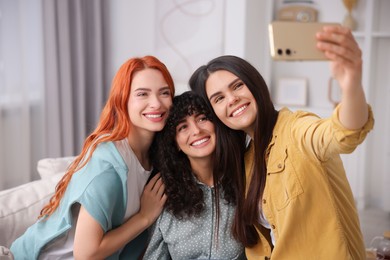Happy young friends taking selfie at home