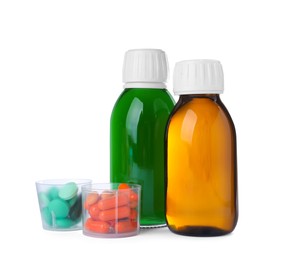 Photo of Bottles of syrups with pills on white background. Cough and cold medicine