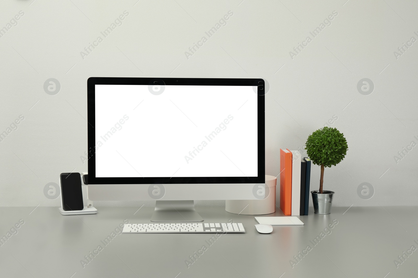 Photo of Modern workplace with computer, charging devices and decor elements. Interior design