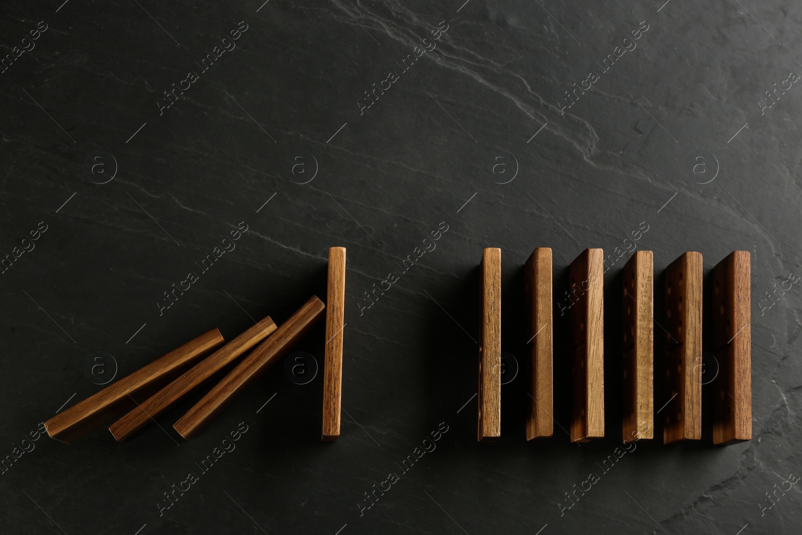 Photo of Wooden domino tiles on dark grey background, flat lay