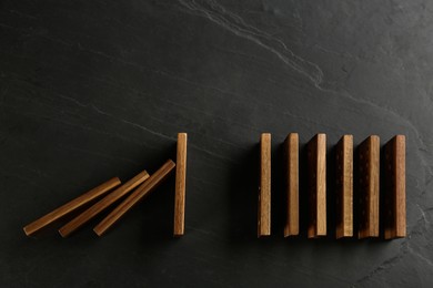 Photo of Wooden domino tiles on dark grey background, flat lay