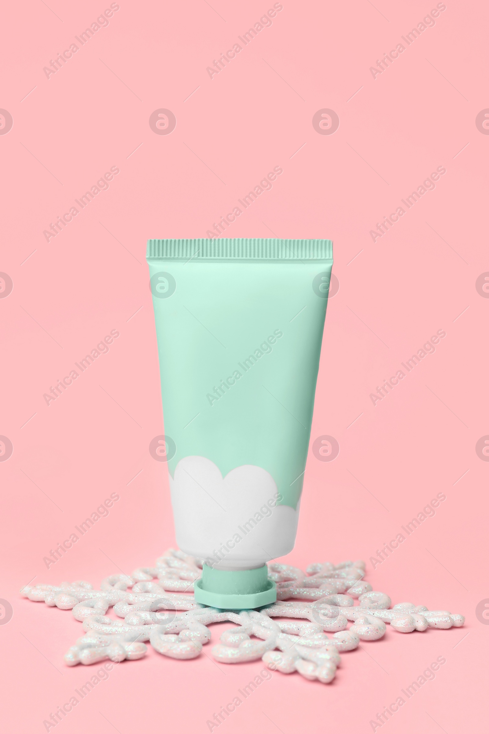 Winter skin care. Stylish presentation of hand cream on pink background Photo of Winter skin care. Stylish presentation of hand cream on pink background