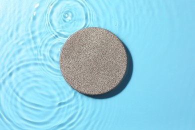 Photo of Presentation for product. Stone podium in water on light blue background, top view