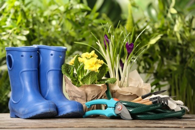 Blooming flowers and gardening equipment on table outdoors