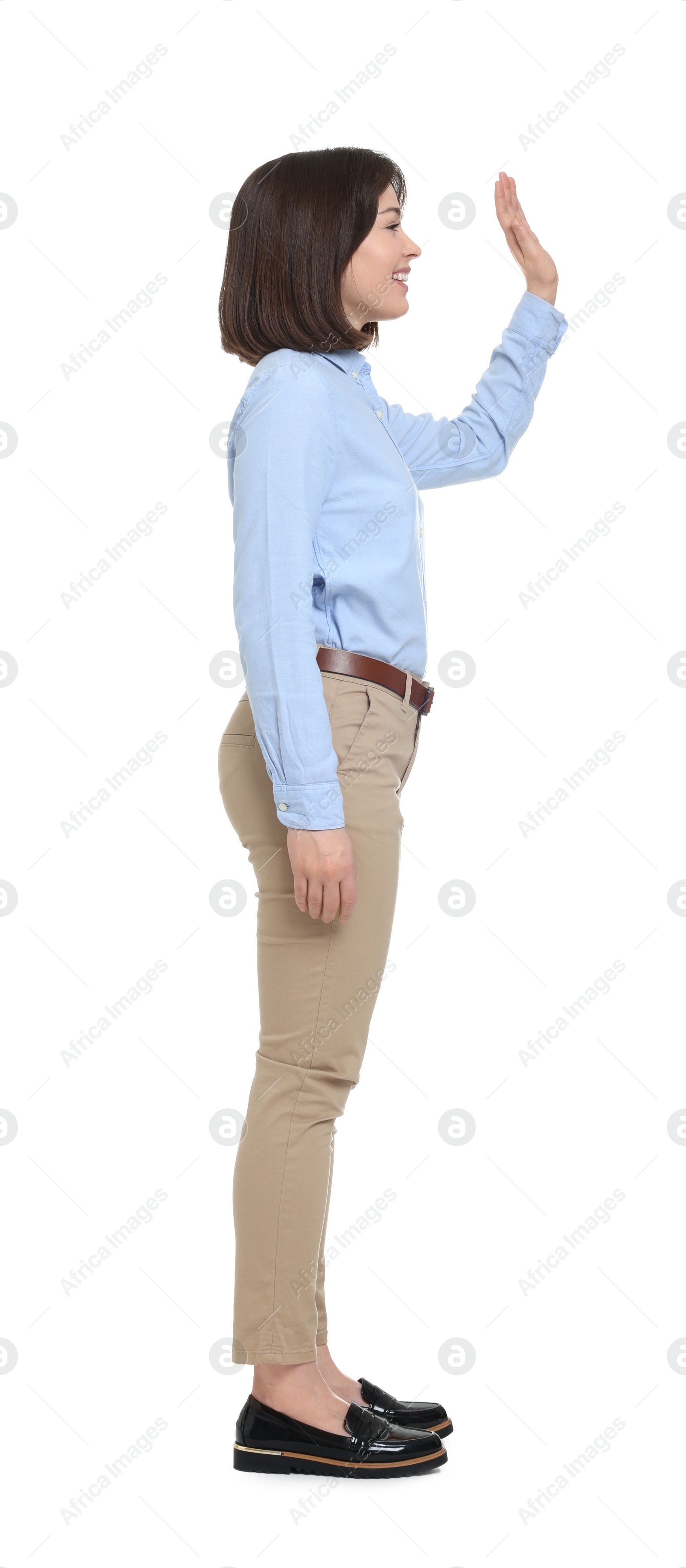 Photo of Happy businesswoman in blue shirt and beige pants on white background