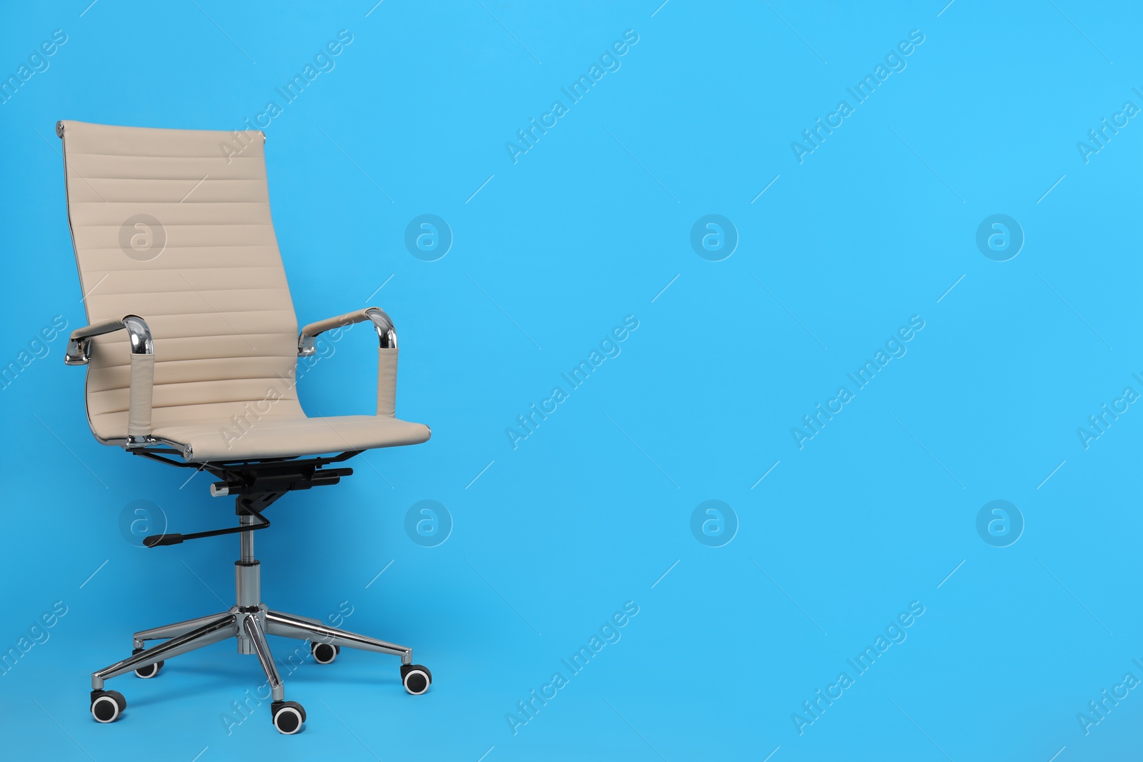 Photo of Comfortable office chair on light blue background, space for text